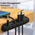 Black five-slot cable organizer holding cables along a wooden desk